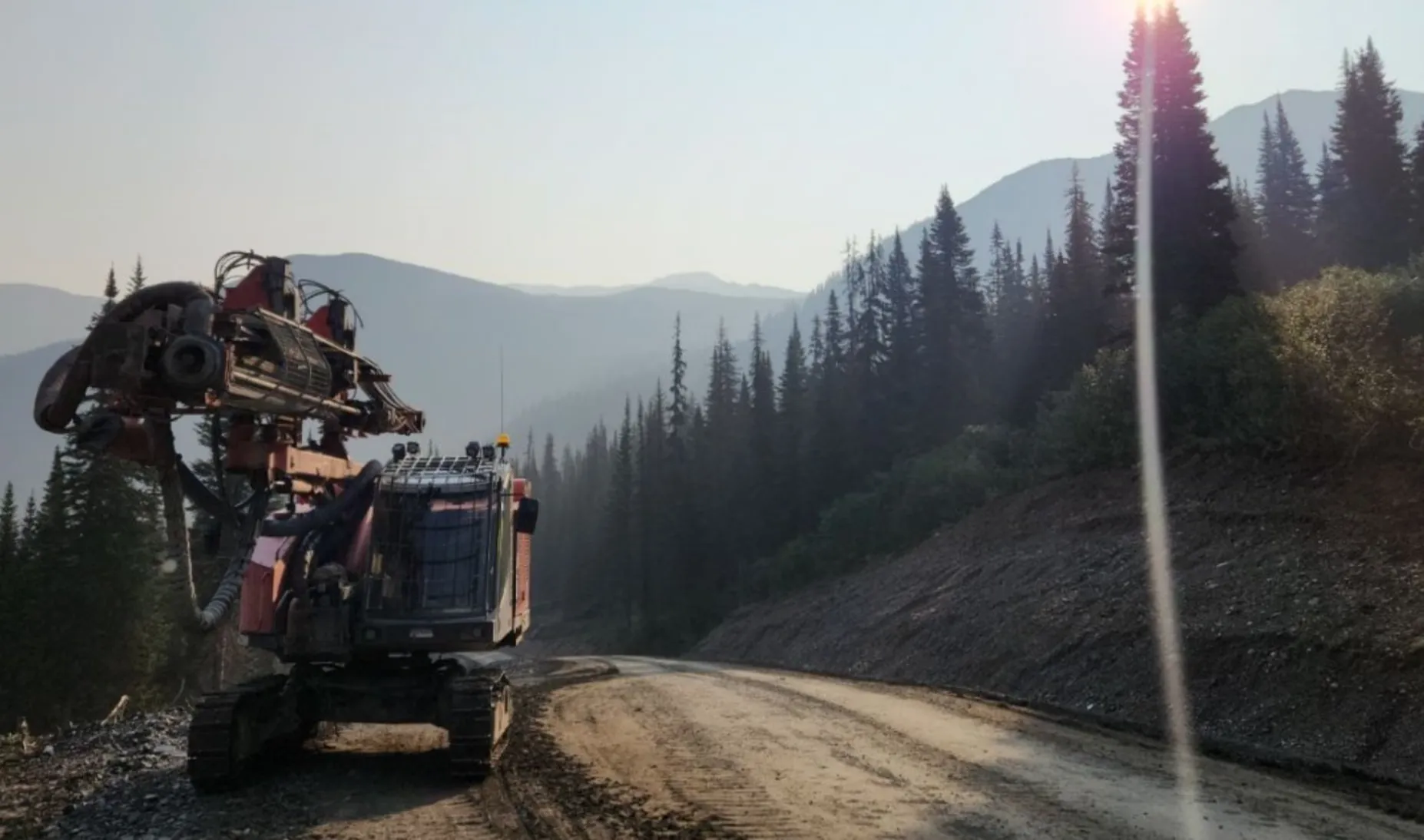 McCaw's tracked drill rig moving along a forest road in the mountains